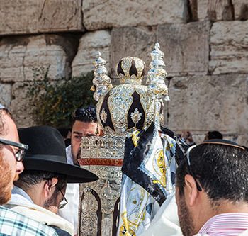 יהודים מתפללים ליד ספר תורה בכותל המערבי