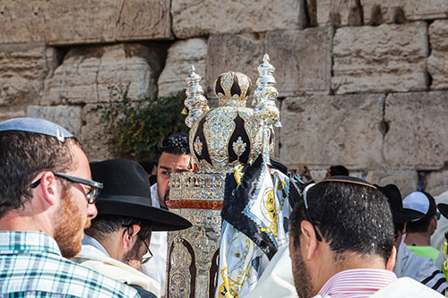 יהודים מתפללים ליד ספר תורה בכותל המערבי